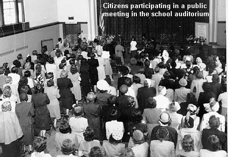 Citizens participating in a public meeting in the school auditorium